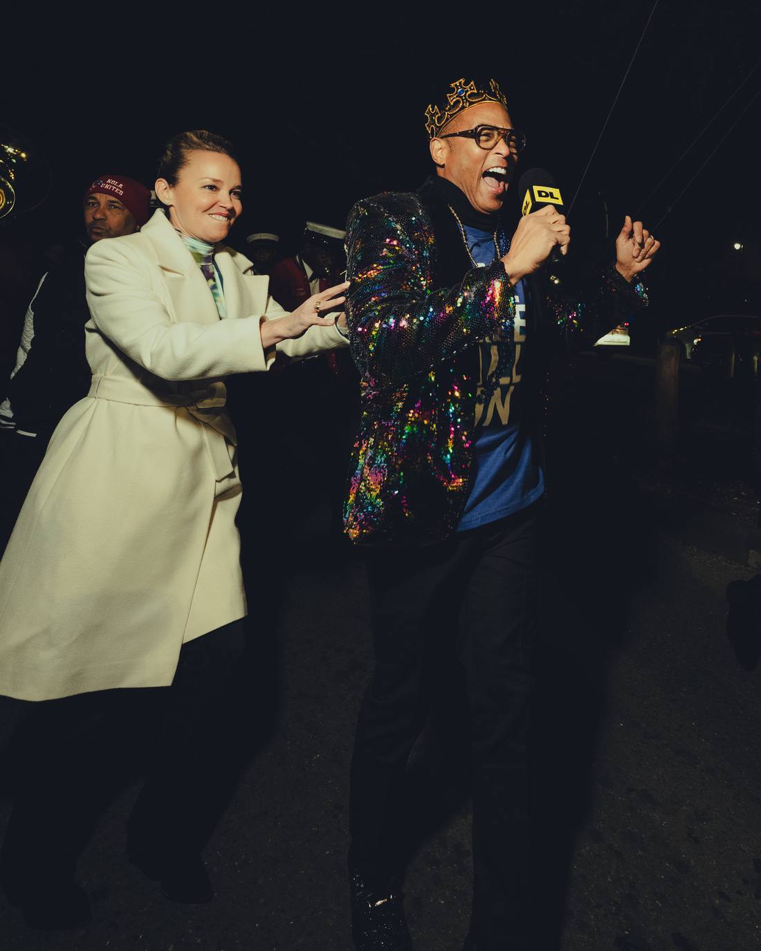Don dancing down the street with a brass band behind him