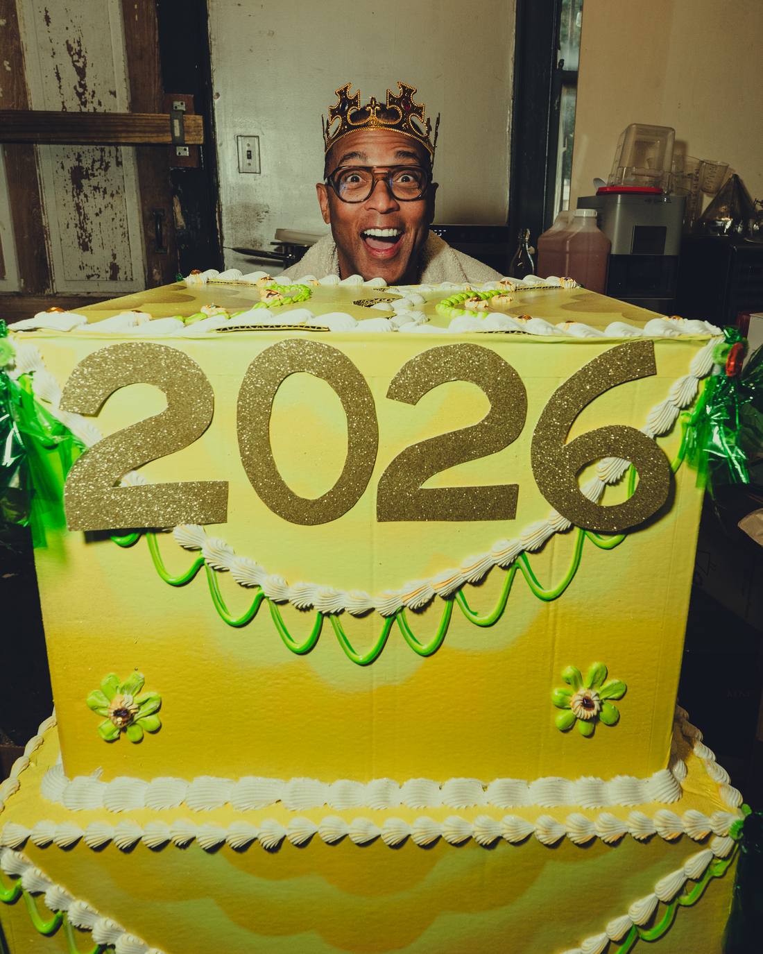 Don in a crown peeking over a giant 2026 cake